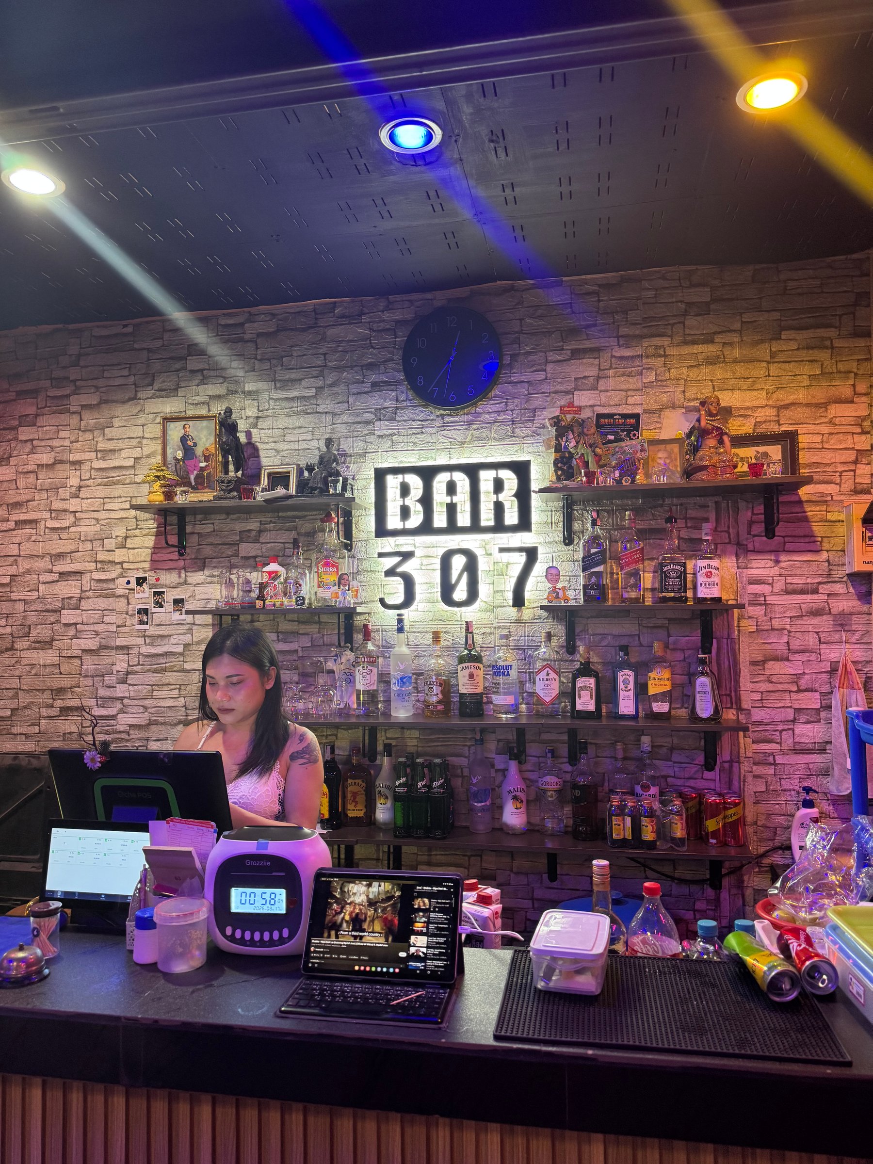 Bar 307 counter with backlit sign and friendly staff